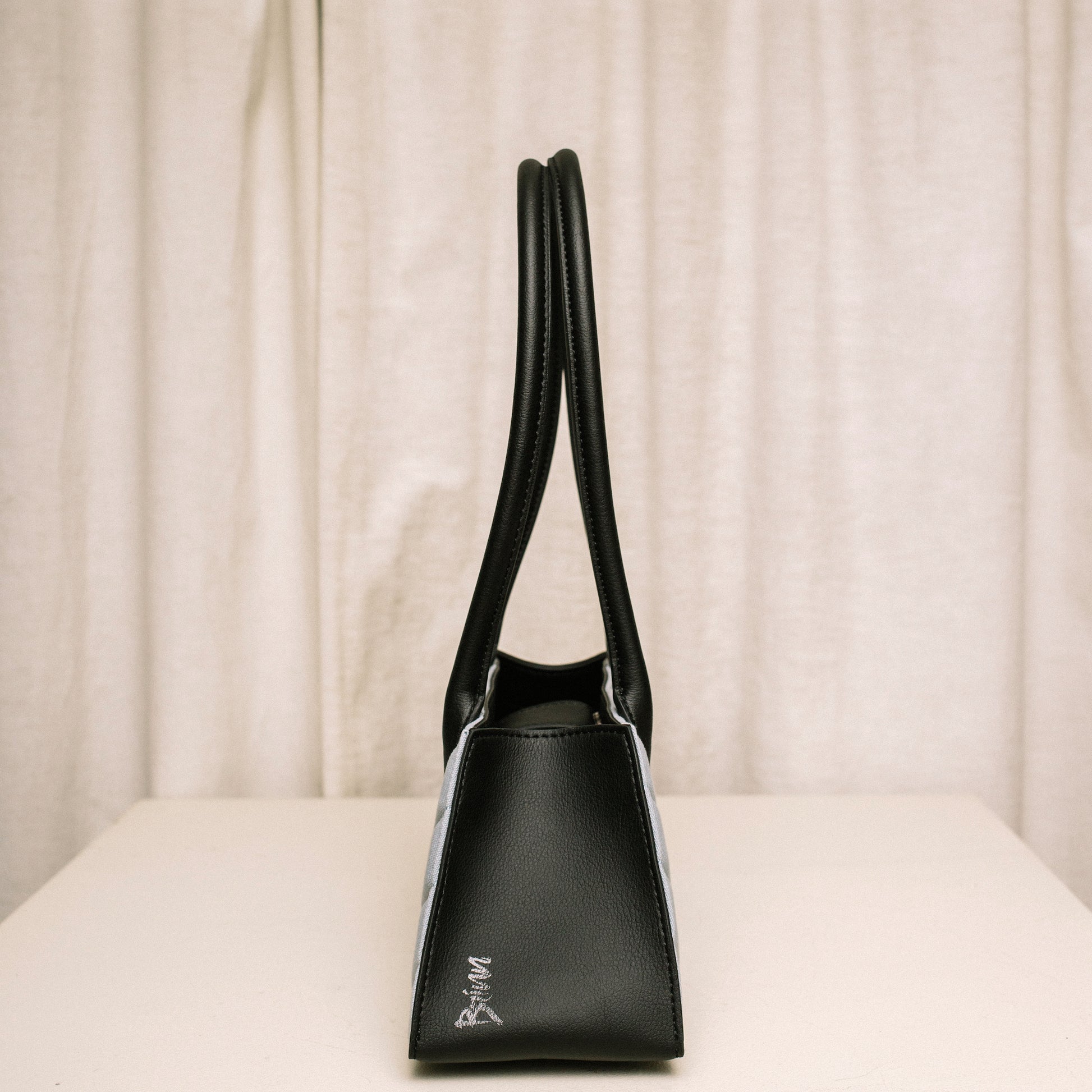 Side view of Honeypie Purse by Brinn highlighting the black cactus leather and embossed Brinn logo on the side of the bag